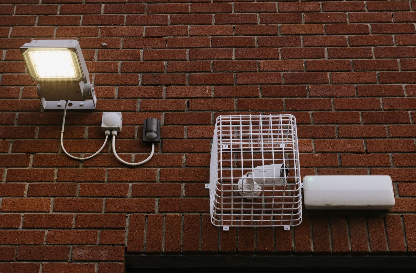 Projecteur, détecteur et caméra protégés sur un mur de brique
